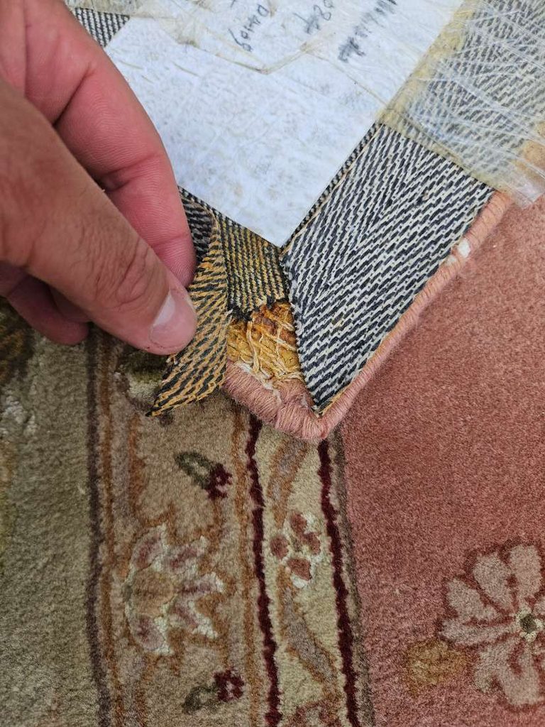 Technician inspecting the backing of an area rug before cleaning in Ocean County, NJ